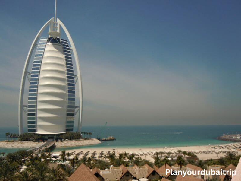 Burj Al Arab in Dubai Burj Al Arab hotel in Dubai with its white sail-shaped design standing on a private island next to the turquoise water.