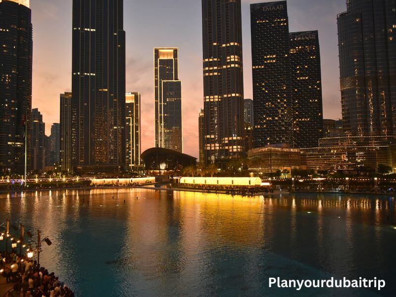 Burj Lake, Dubai Burj Lake in Dubai at dusk with tall buildings lit up around the water and golden reflections on the lake surface.