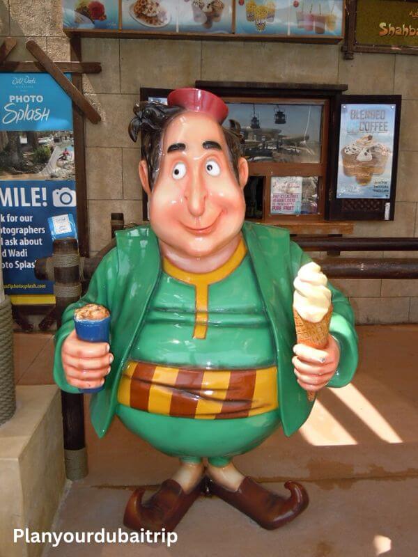 Cartoon character statue holding a drink and ice cream cone outside the food court at Wild Wadi Water Park in Dubai.