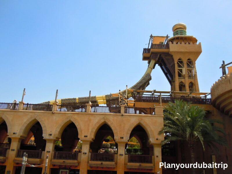 Jumeirah Sceirah water slide at Wild Wadi Water Park in Dubai with a tall tower and steep drop slide against a blue sky.