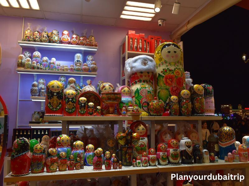 Matryoshkas in Russian Pavilion in Dubai Global Village Matryoshka nesting dolls on display at the Russian pavilion in Dubai Global Village with shelves full of painted dolls in different sizes and colors.